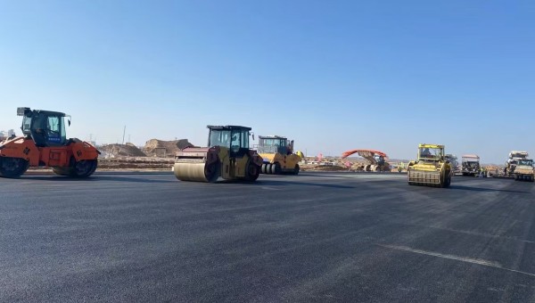 近日，在西部市政建設(shè)集團蘭州新區(qū)城市礦產(chǎn)與表面處理產(chǎn)業(yè)園區(qū)（二期）周邊基礎(chǔ)設(shè)施項目—園區(qū)西路南延段（緯五十路至緯二十八路）項目現(xiàn)場，隨著一輛輛運料車平穩(wěn)駛?cè)?，攤鋪機將滾燙的瀝青混合料均勻鋪開，標(biāo)志著項